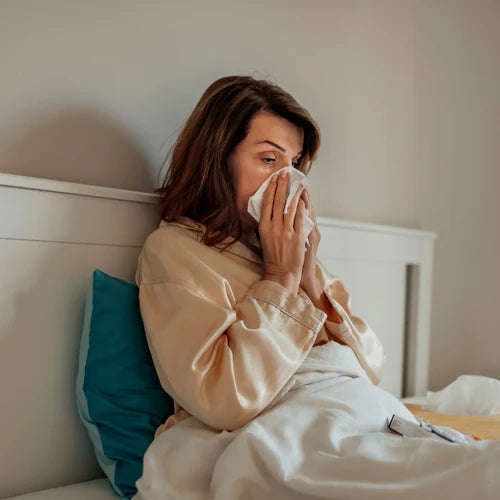 Woman in bed with a tissue, representing the use of powerful peptides to boost the immune system and improve health