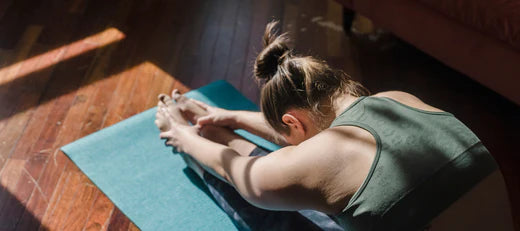 Woman stretching on a yoga mat, symbolizing enhanced physical performance through peptide solutions