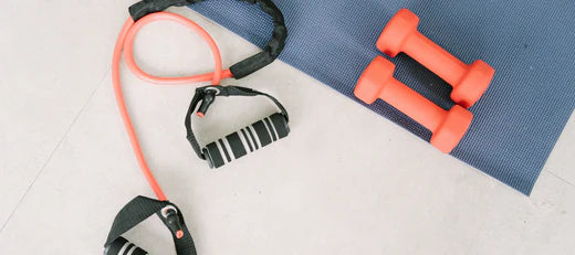 Exercise equipment including resistance bands and dumbbells, representing natural healing and better health through peptide therapy