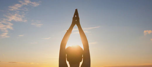 Silhouette of a person doing yoga at sunrise, symbolizing the benefits of peptide therapy for anti-aging and wellness