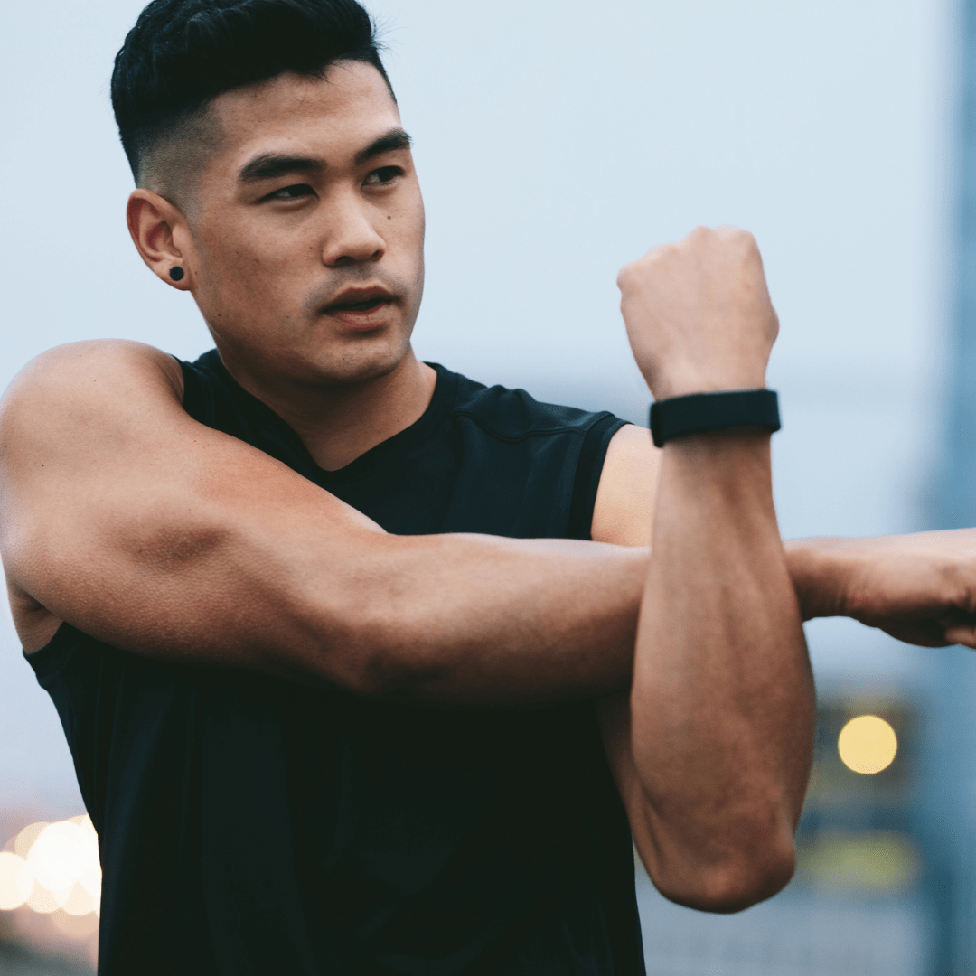 Jonathan Lee stretching his arms after a workout, sharing his experience with CJC-1295 & Ipamorelin for improved muscle growth and faster recovery, thanks to BioFusion Peptides' seamless support and expertise.





