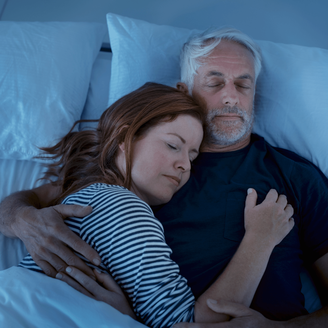 Individual sleeping with a sleep mask in a dark, peaceful setting, representing improved sleep quality through BioFusion Peptides' therapies