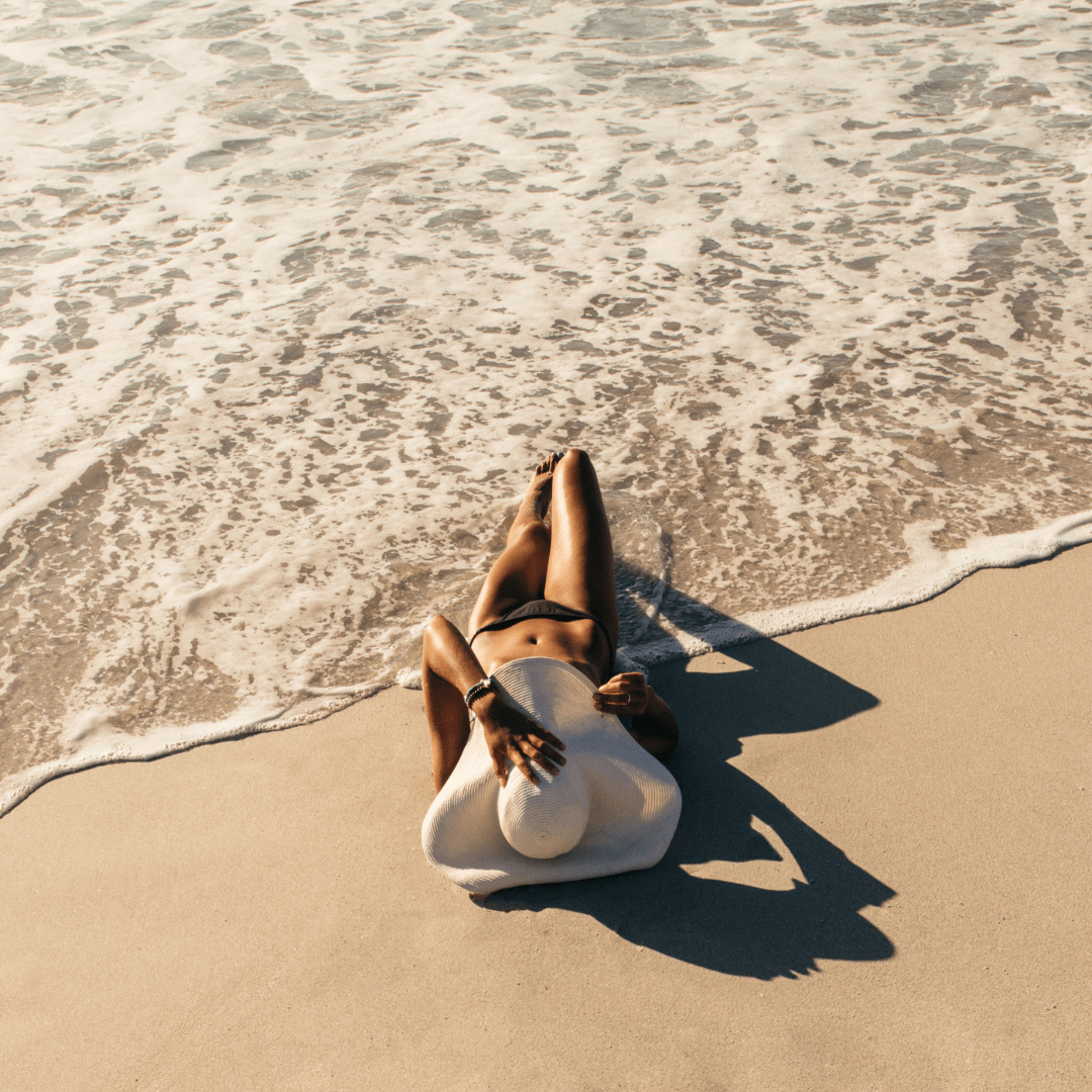 Woman relaxing on the beach, representing tanning benefits from BioFusion Peptides’ advanced therapies