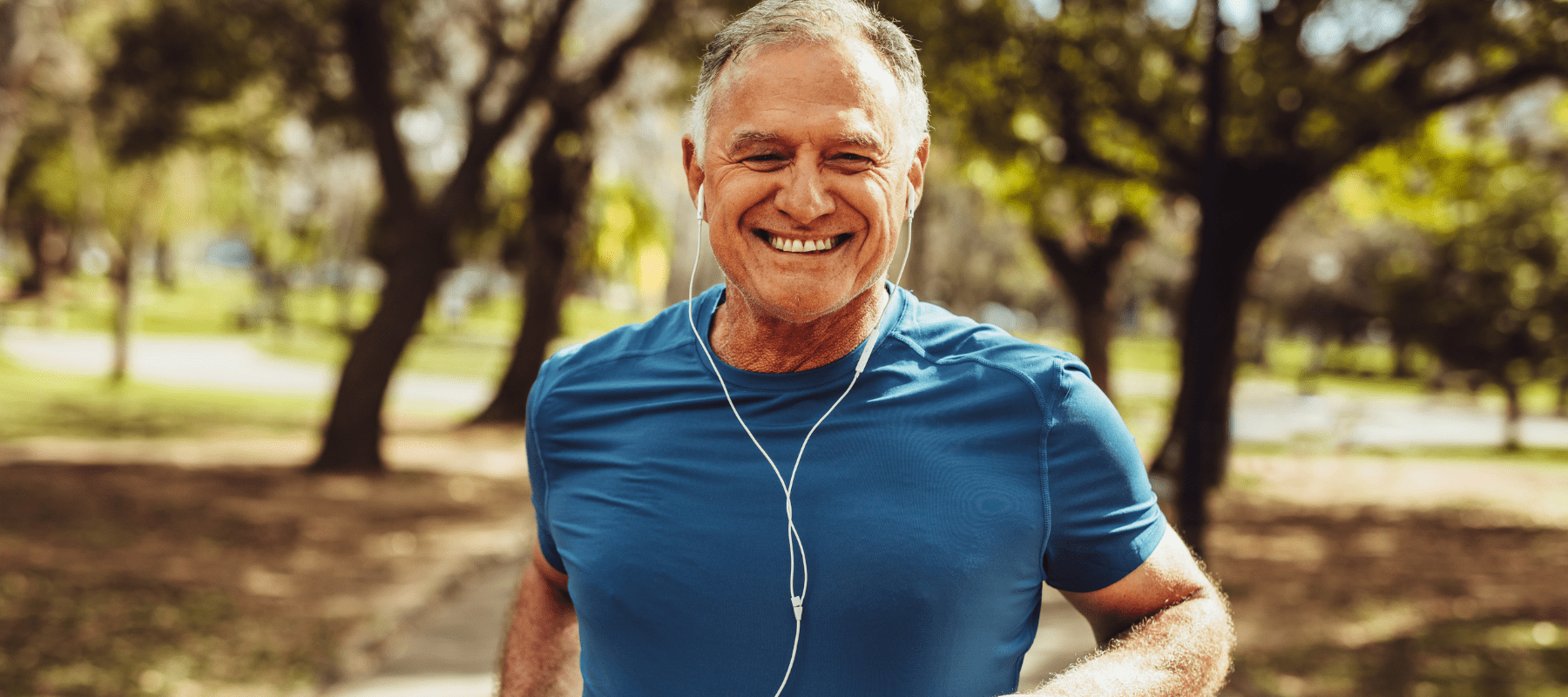 Active older man jogging in a sunny park, representing vitality and wellness supported by peptide therapy featured in BioFusion’s Peptide Insight blog series